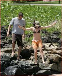 Alyson et Alexis descendent pieds nus des rochers vers la plage