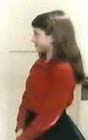 En chemise rouge et jupe noire avec ses attributs artificiels