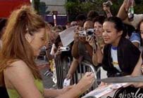 Signant des autographes aux fans derrire les barrires