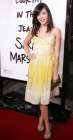Alyson sur le tapis rouge devant une affiche du film