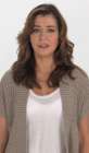 Alyson avec un gilet beige par-dessus un T-Shirt blanc