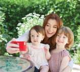 Alyson se prenant en photo avec ses 2 filles souriantes