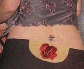 Tatouage Kanji japonais dans le bas du dos découvert par le pantalon taille basse