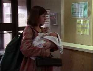 Cassie arrive à la gare avec son baluchon son bébé dans les bras et elle tien le coffret de sa flute